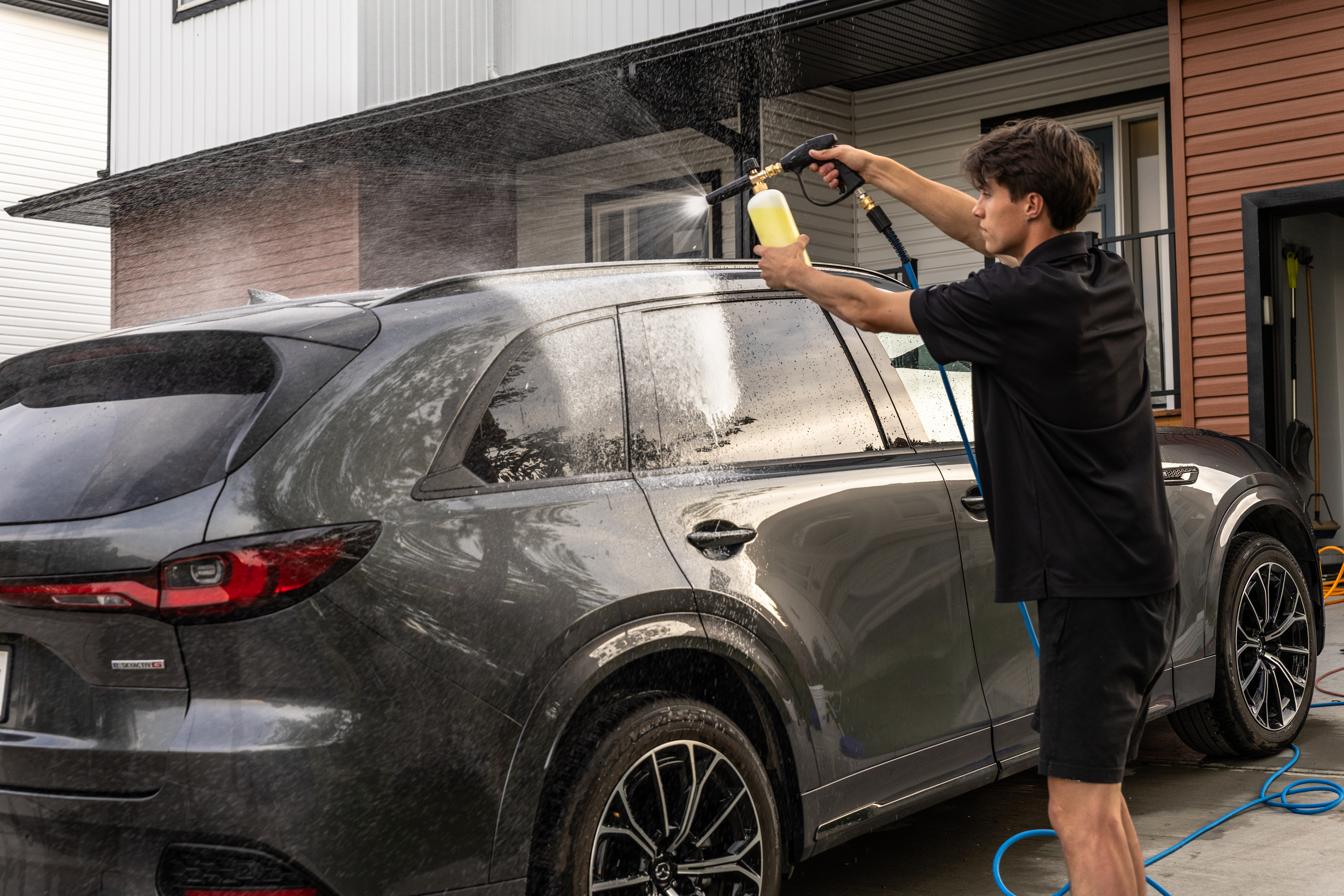 Foam cannon pre-wash on a dark SUV